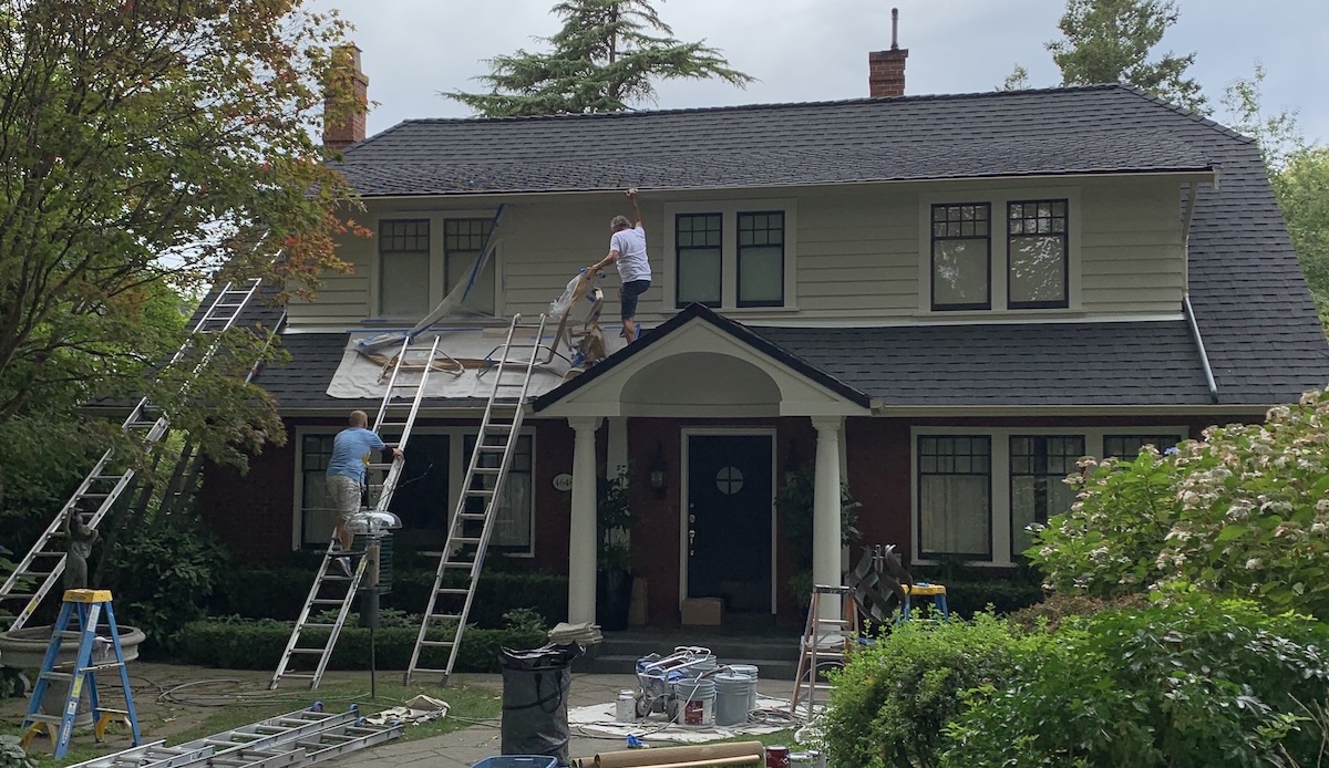 An employer supervising a house painting project in Coquitlam.